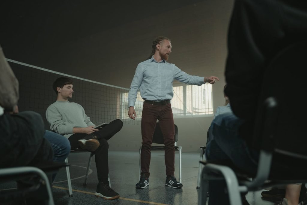 A group therapy session indoors with diverse adults engaging in discussion and support.